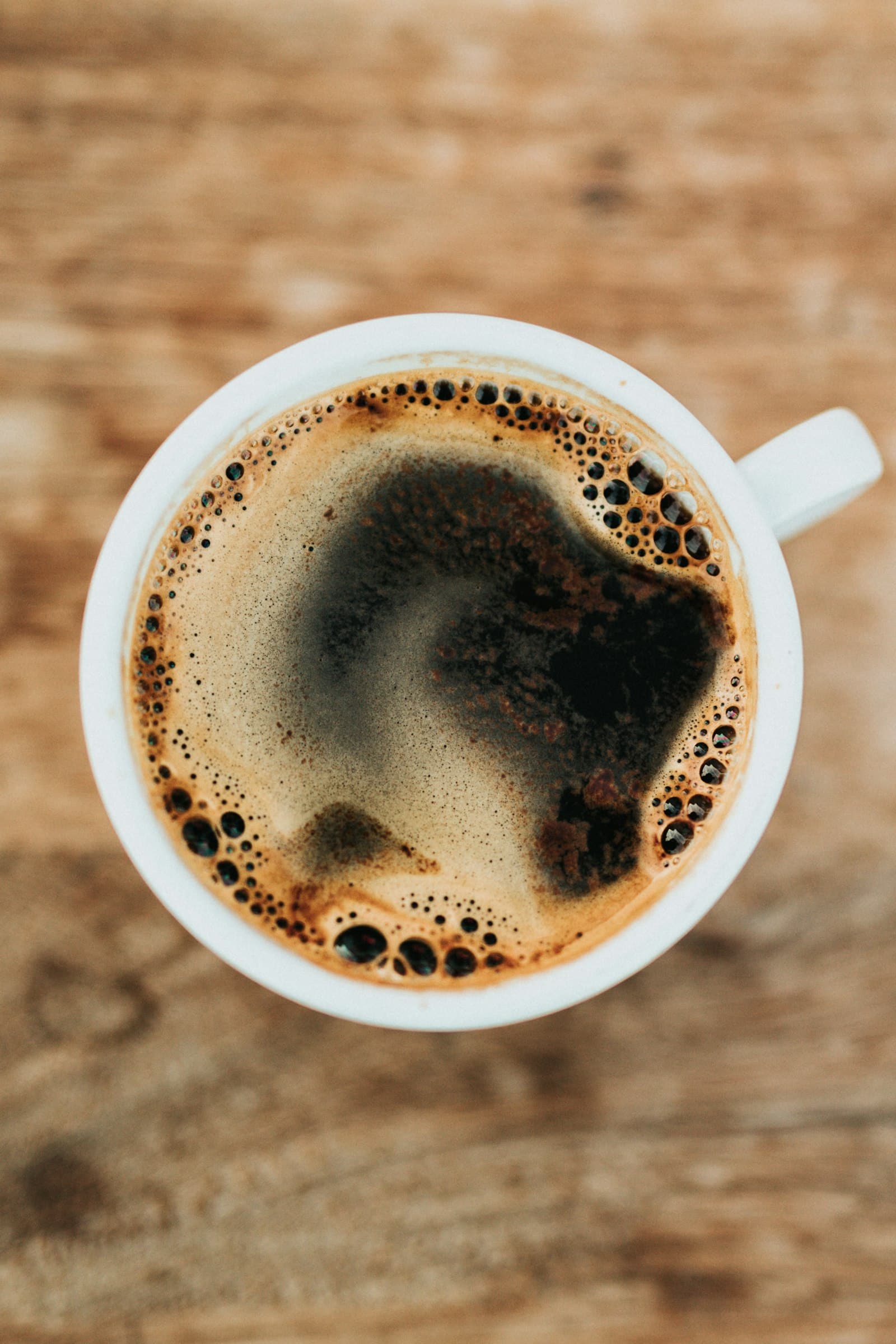 Café noir vu de dessus, crema dorée dans une tasse blanche