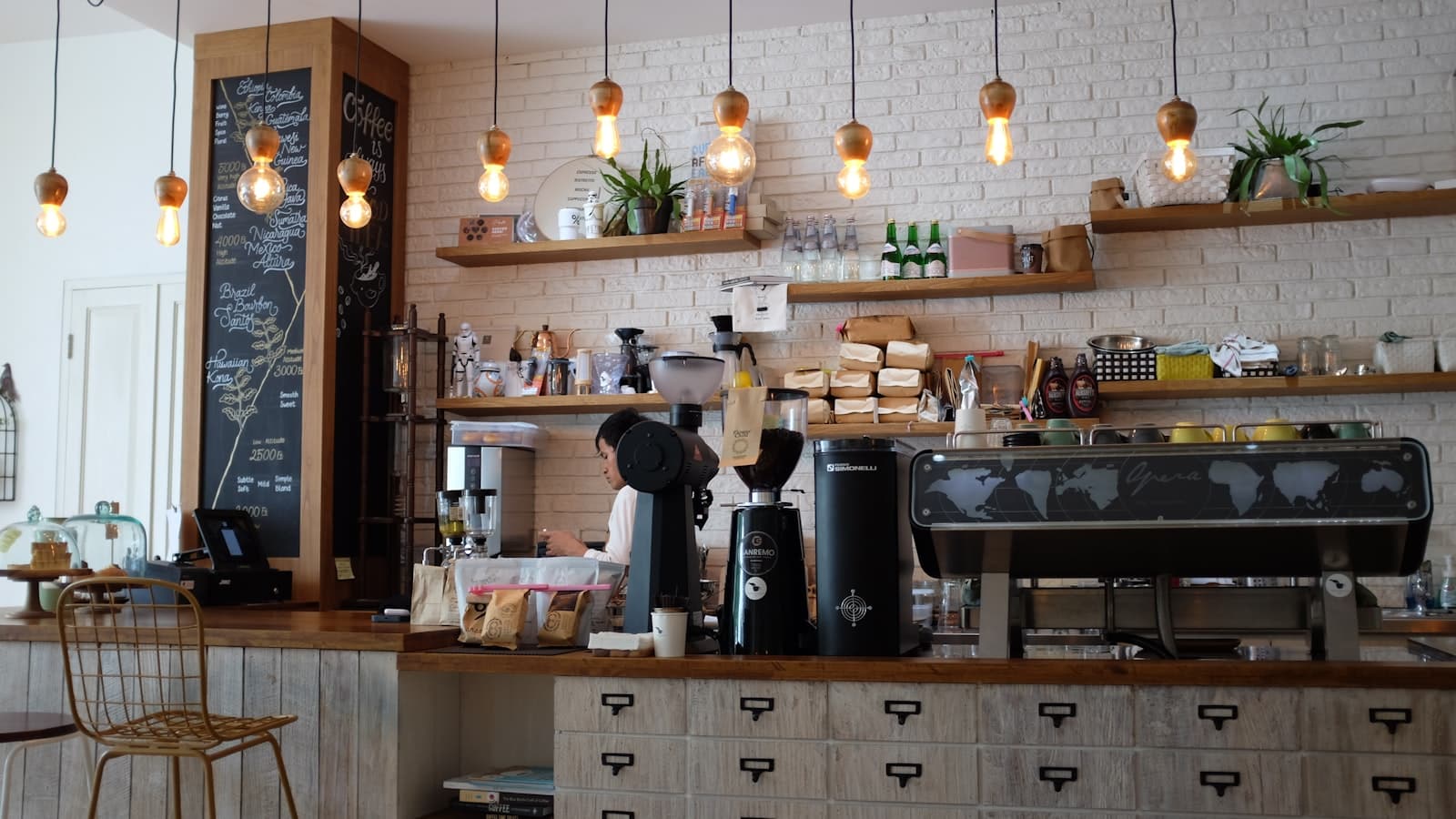 Comptoir du coffee bar avec machine espresso, moulins et ampoules suspendues