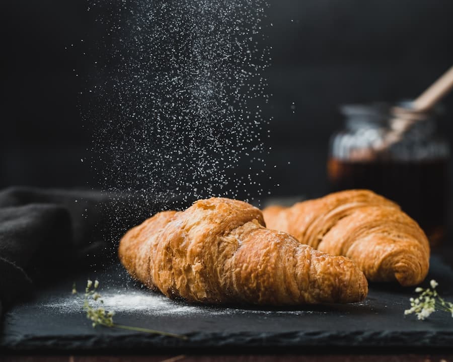 Croissants au beurre saupoudrés de sucre glace sur une ardoise