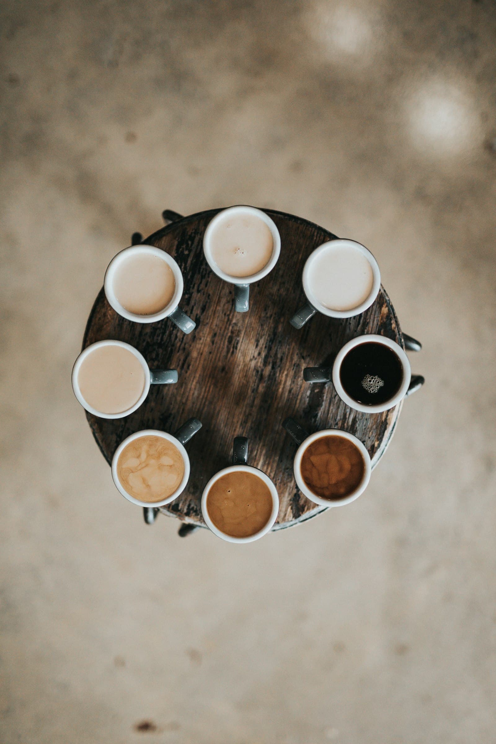 Huit tasses de café disposées en cercle, du lait au noir intense