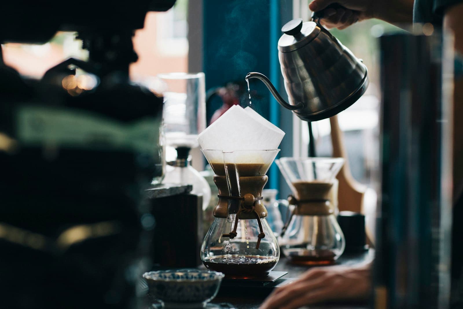 Barista versant l'eau chaude en spirale sur un filtre Chemex
